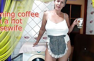 Morning coffee with a joyful hot housewife chatting with fans over a cup of coffee while sitting on a washing machine.